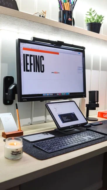 High-angle view of a stylish work desk featuring dual monitors, keyboard, mouse, and modern accessories.